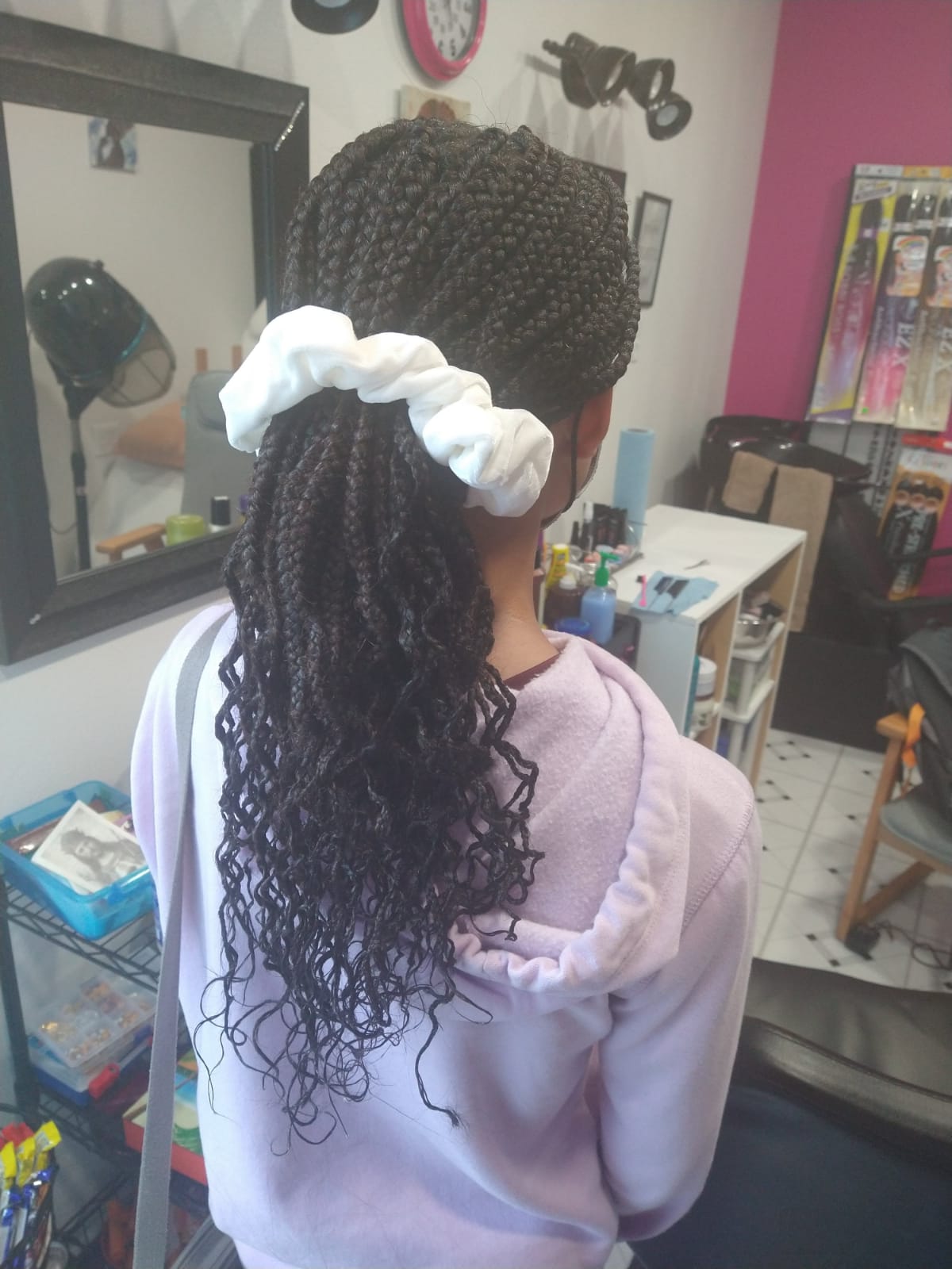 Black braid hairstyle with white scrunchie holding ponytail