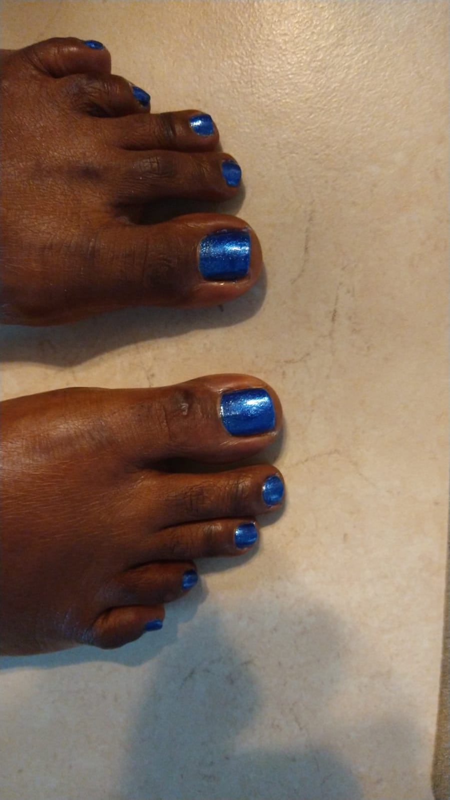 Toenails painted a deep glossy blue